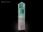 Bi-color tourmaline crystal from Afghanistan with a light pink base and grass-green termination, candy-like shape, and bright luster.