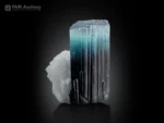 Tourmaline crystal showing black base and blue-green termination on white matrix.
