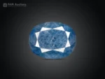 12.95 ct oval cut blue sapphire gemstone from Madagascar showing pink fluorescence under UV light