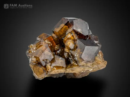 Brown andradite garnet crystals with glossy luster and sharp faces on natural matrix.