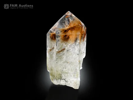 Quartz crystal with golden rutile needle inclusions and defined termination on dark background.