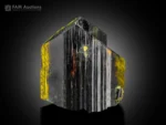 Dark epidote crystal with strong vertical striations and yellow mineralization accents.