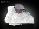 Deep red spessartine garnet crystal on white calcite with green chlorite.