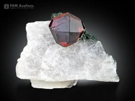 Deep red spessartine garnet crystal on white calcite with green chlorite.