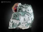 Deep red spessartine garnet crystal on white calcite with green chlorite.