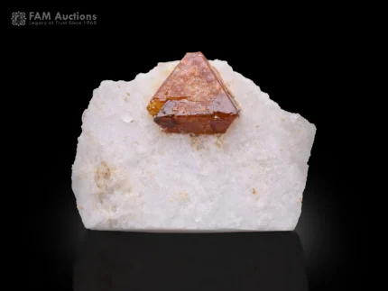 Microlite crystal on white feldspar matrix with sharp geometry and contrast.