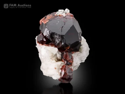 Dark red spessartine garnet crystal on white albite matrix with strong contrast.