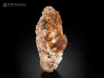 Orange-brown bastnasite crystals on a contrasting matrix.