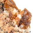 Orange-brown bastnasite crystals on a contrasting matrix.