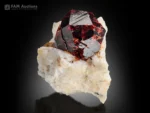 deep red spessartine garnet crystal on albite matrix with muscovite and strong color contrast.