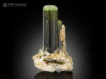 Green tourmaline crystals with mica, cleavelandite, and spessartine garnet on matrix.
