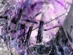 Purple fluorite crystals with dark riebeckite inclusions and contrasting albite.